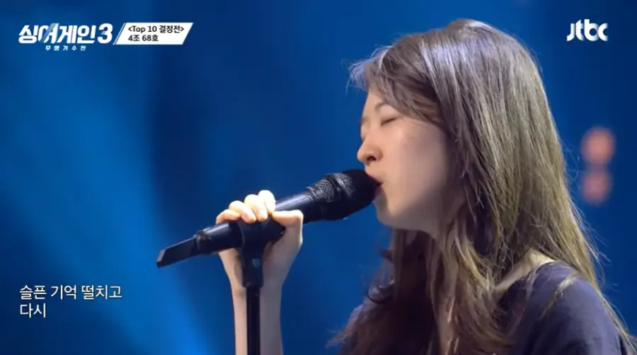 싱어게인3-
긴생머리 파란니트 검은 스탠딩마이크를 잡고 노래하는 68호