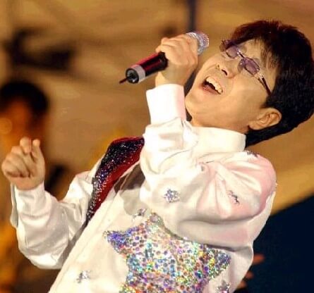 조용필이-별-모양의-문의가-있는-하얀-재킷을-입고-왼손에-마이크를-들고-열창하는-모습