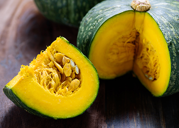 단호박의 1/4로 잘려져 있고 노란속과 씨앗이 보여지고 있다.