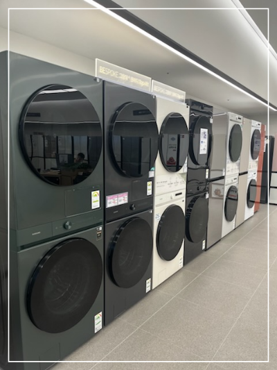 삼성스토어-용인시청점에-전시된-다양한-색상의-비스포크-세탁기와-건조기.-여러-모델이-깔끔하게-정렬되어-있으며,-최신-가전제품을-직접-비교해볼-수-있는-공간.