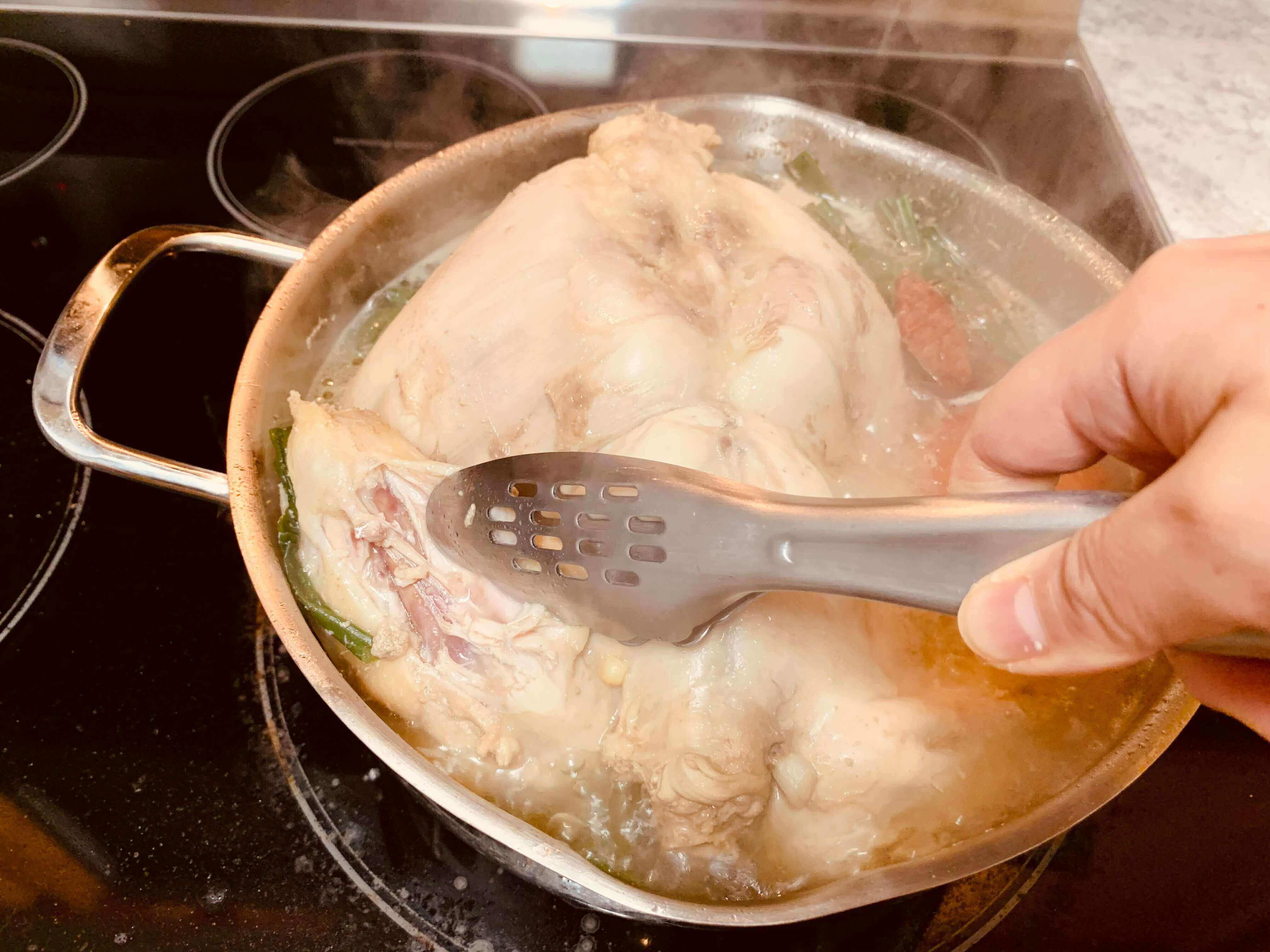 끓는-냄비-안-치킨 다리를-집게로-집는-모습