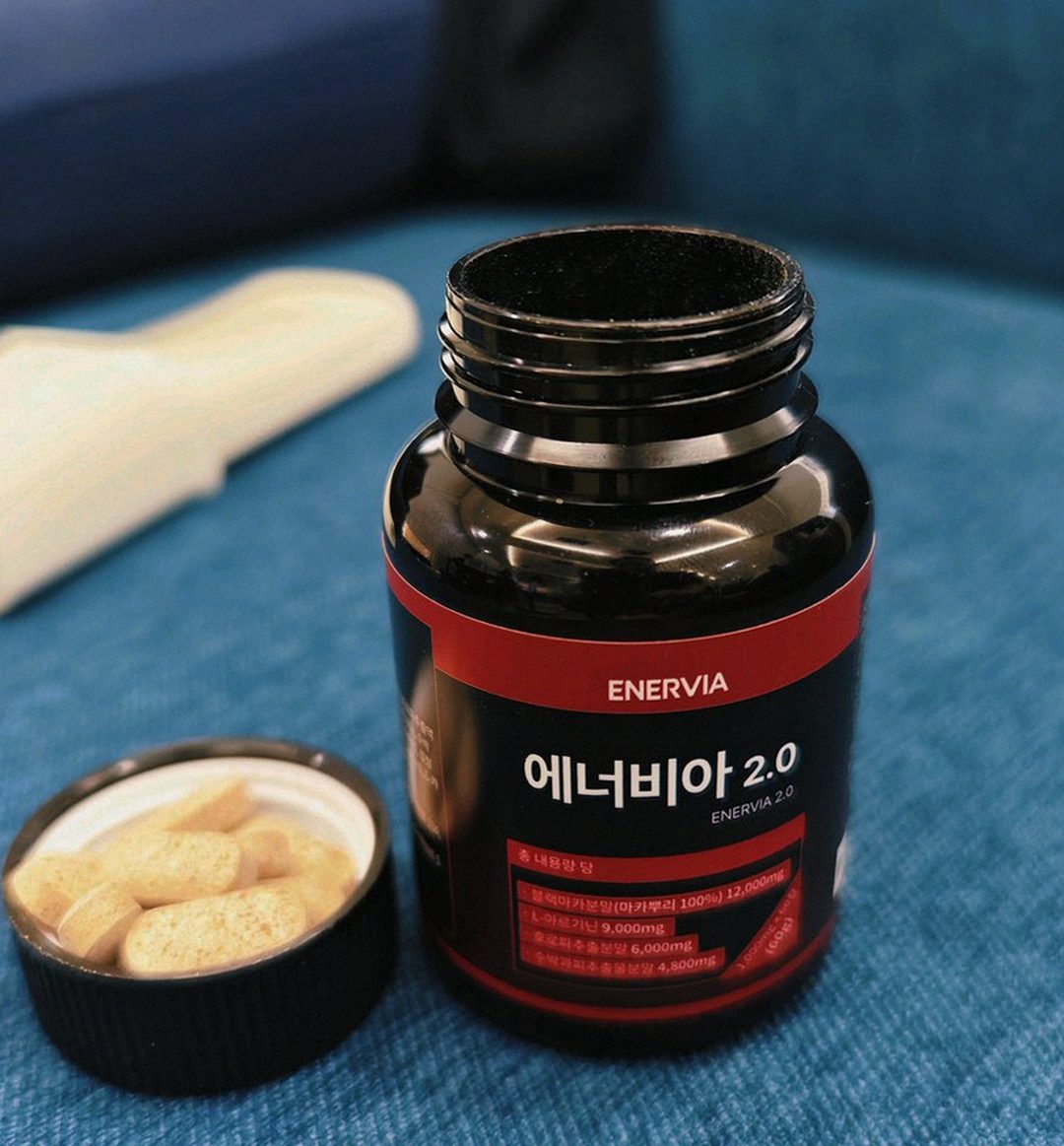 Korean Asian man 46 taking supplement with water at lunch time natural light