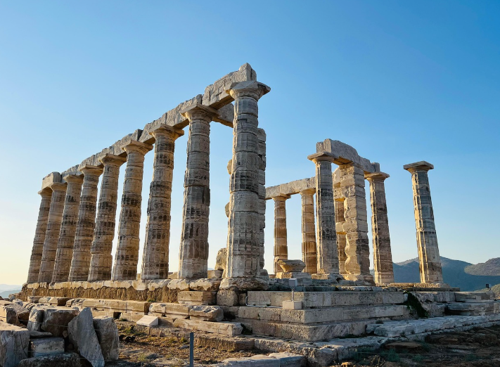파란 하늘 아래 기둥만 남은 부서진 사원이 위치해 있다(아테네)