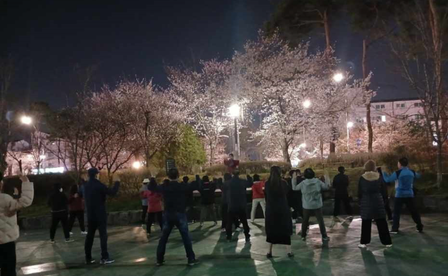 주민들이 야간에 전문 강사 지도하에 즐겁게 체조하는 모습