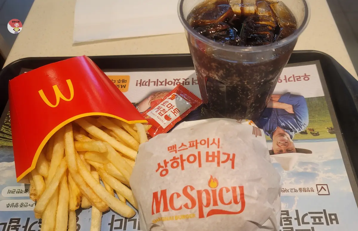 트레이에 담긴 맥도널드 상하이 맥스파이시 버거 세트, 후렌치 후라이, 종이로 포장된 상하이버거, 케찹, 코카콜라
