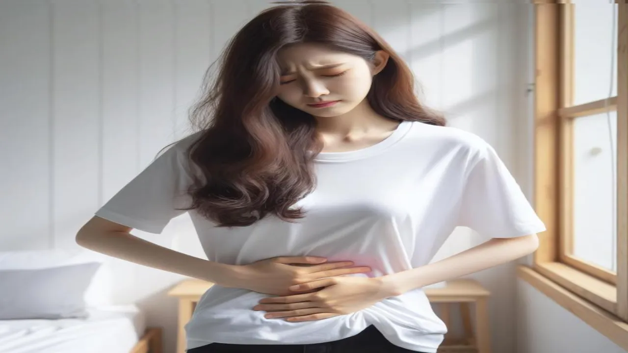 여성의 아랫배를 만지며 착상혈 증상을 느끼는 장면입니다.