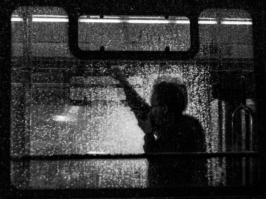 Silhouette of a person on a bus in Buenos Aires during rain.