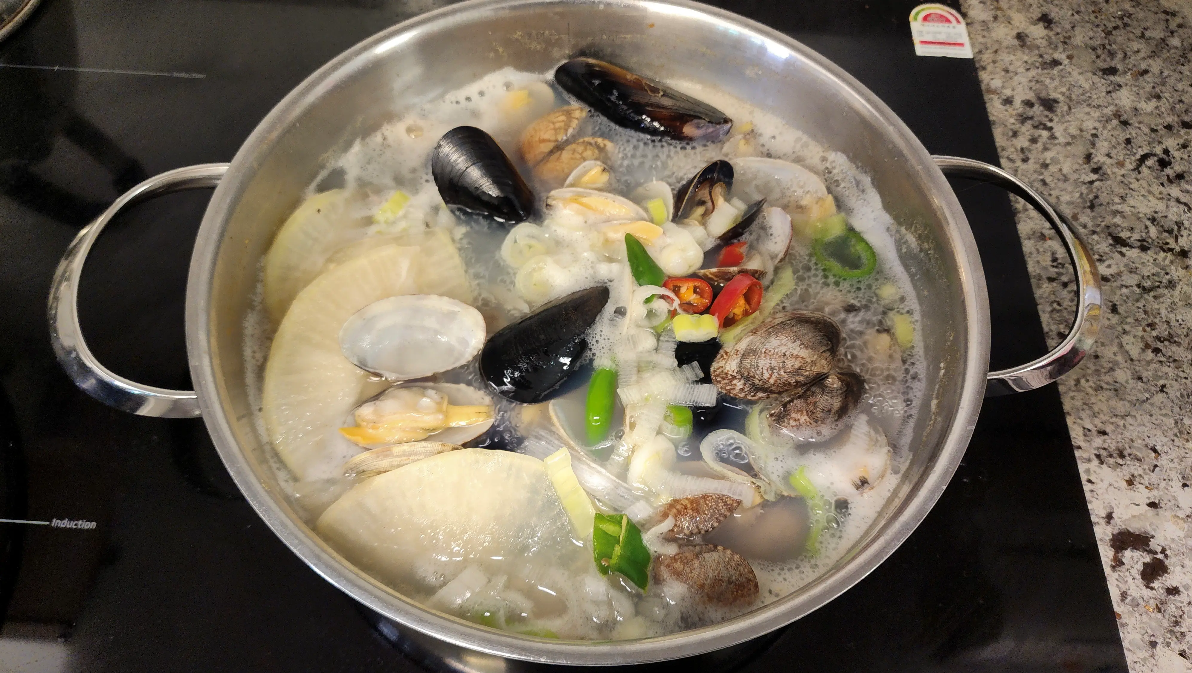 홍합과-바지락과-국물이-들어-있는-넓은냄비가-전기렌지-위에서-끓고-있는사진-01