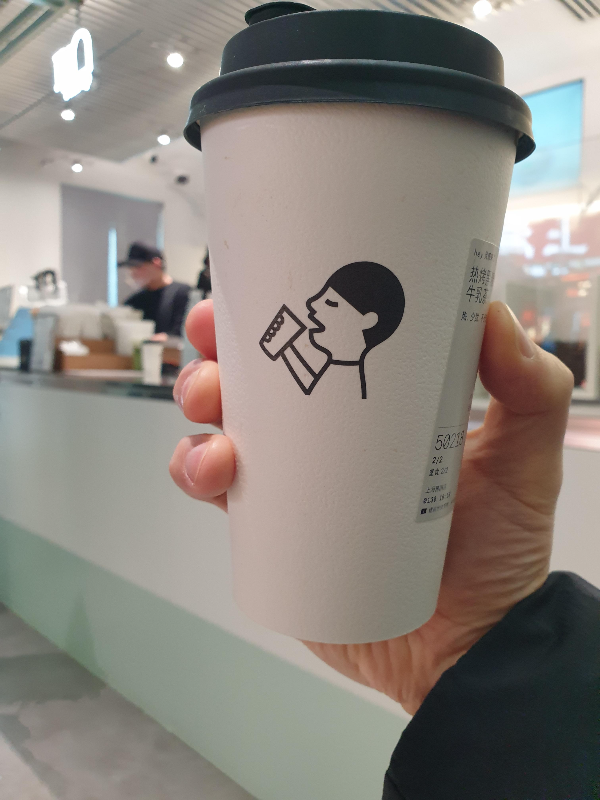 뜨거운 흑당 버블 밀크티를 들고 사진을 찍는 모습