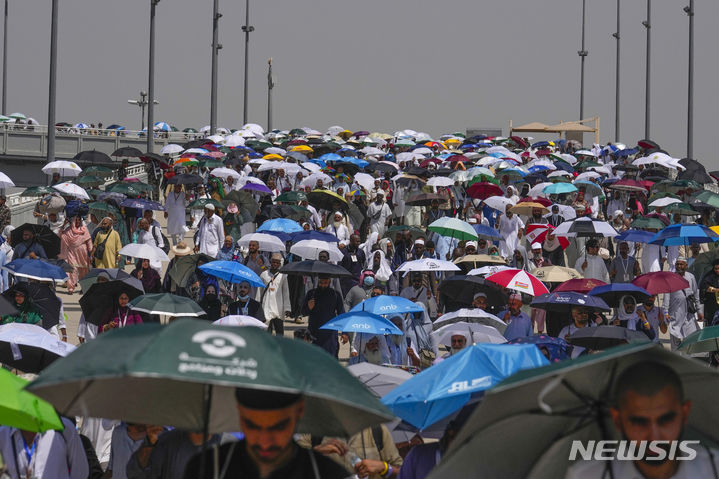 이슬람 최고 성지 사우디아라비아 메카와 메디나를 찾는 성지순례(하지)에서 폭염으로 인해 숨진 사람이 1300명을 넘긴 것으로 전해졌다. 사진은 이슬람 순례객들이 지난 18일(현지시각) 메카 인근 미나에서 햇빛을 가리기 위해 우산을 쓴 채 악마를 상징하는 기둥에 돌을 던지기 위해 몰려드는 모습. 출처 뉴시스