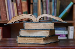 열심히 공부한 3권의 책 위에 공부중인 1권의 펼쳐진 책