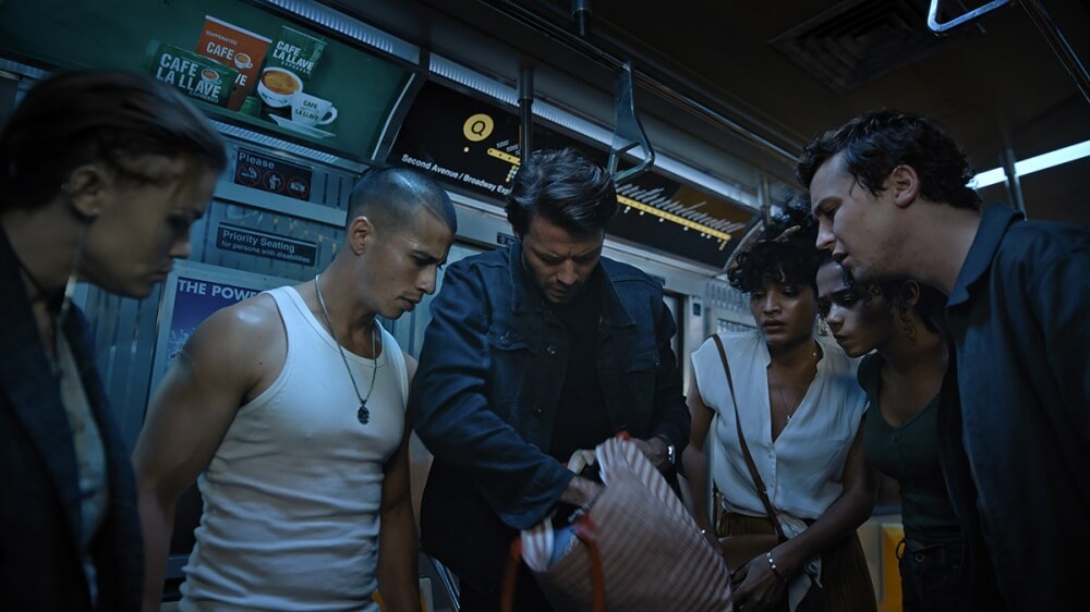 영화 이스케이프 룸 2 스틸컷 – 지하철 안에서 참가자들이 탈출 방법을 찾기 위해 모여 있는 장면