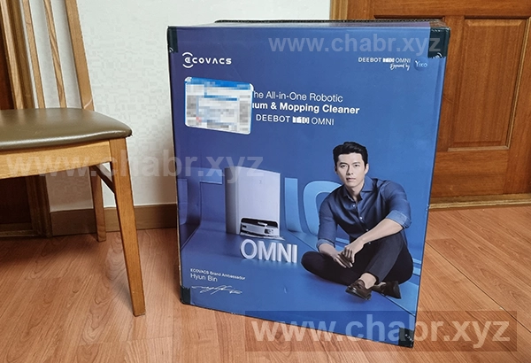 에코백스 T10 옴니 택배박스와 식탁의자를 크기 비교하는 사진