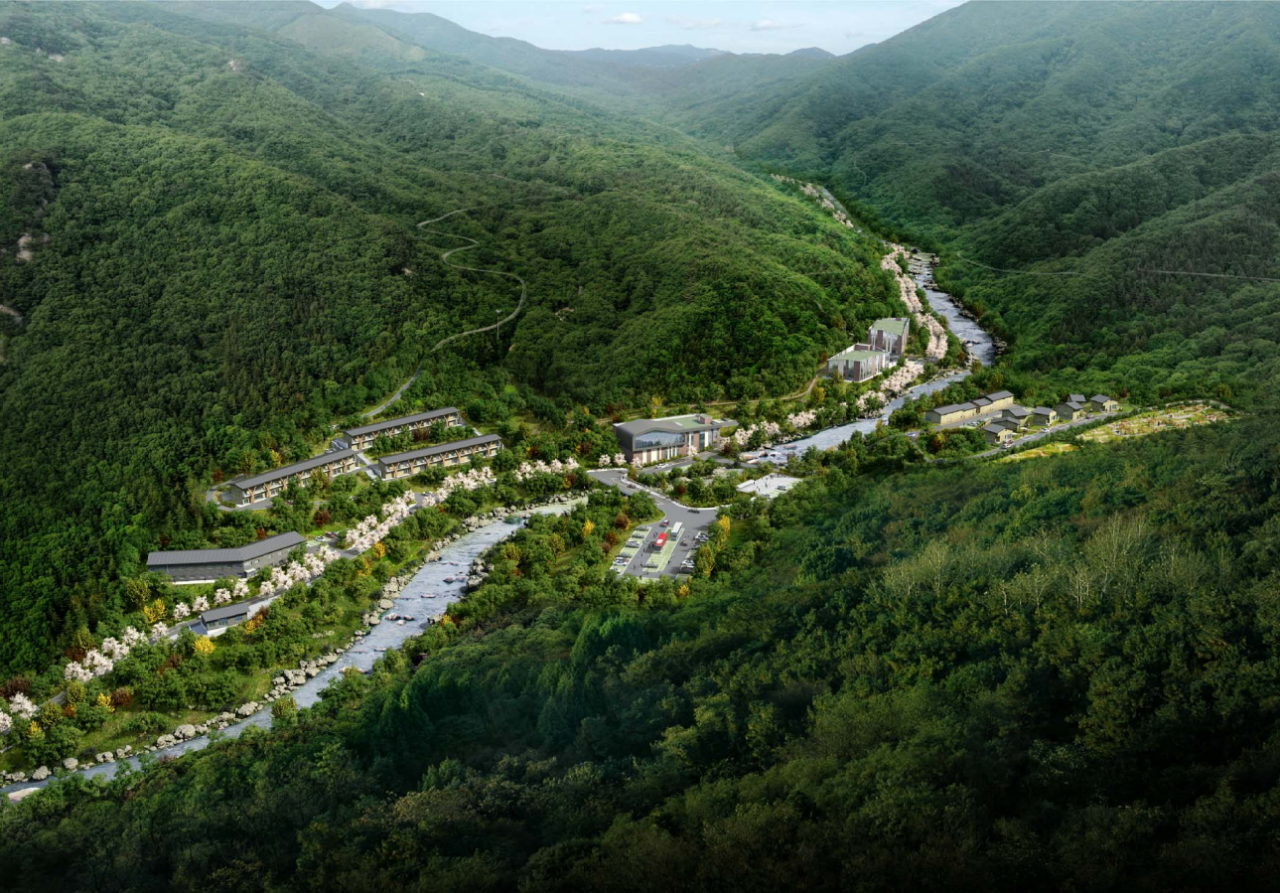 첩첩산중 진안고원의 능선을 배경으로 현대적이고 정갈한 목조 건축물이 숲과 하나 된 듯 자리 잡고 있으며, 구름이 손에 잡힐 듯 가까이 있는 국립진안고원산림치유원의 전경