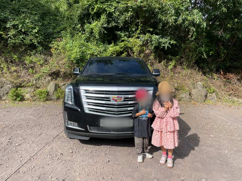 에스컬레이드 앞에 아이들이 서있는데 차가 엄청나게 커보입니다.