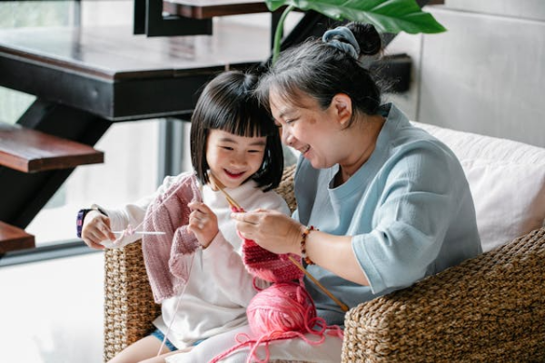 엄마와 딸이 함께 뜨개질하며 행복해하는 사진