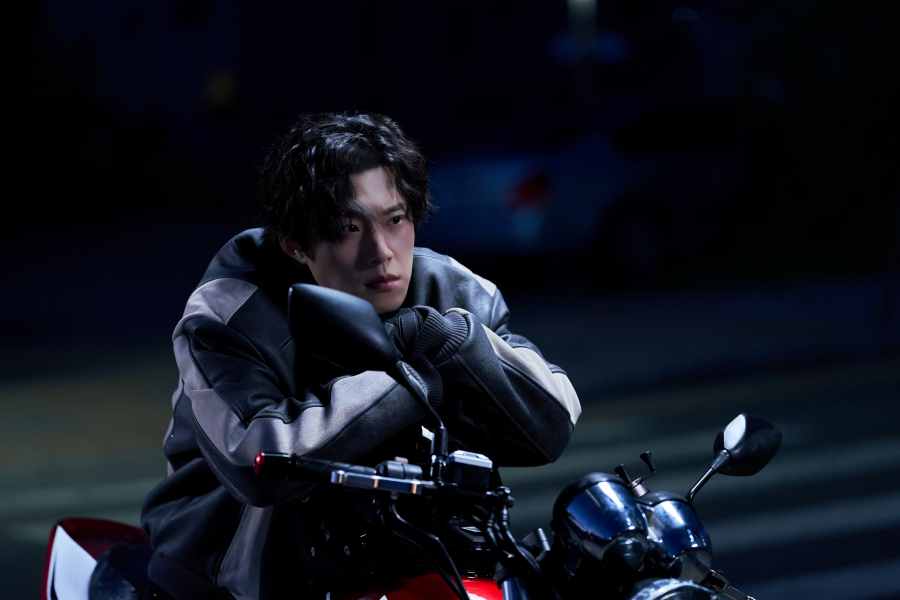 한 남자가 오토바이에 앉아서 앞을 바라보고 있다.