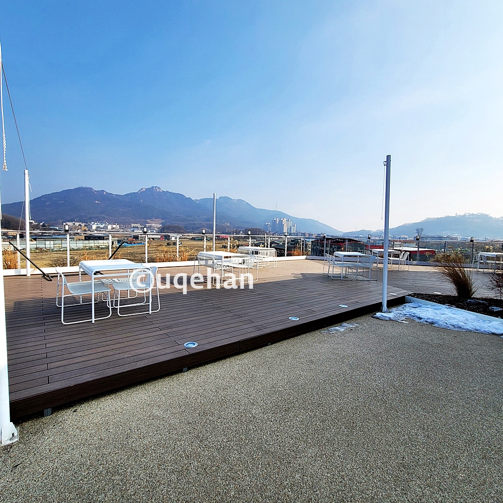 모씨 카페 루프탑 외부 데크 위에 테이블과 의자가 설치되어 있따.