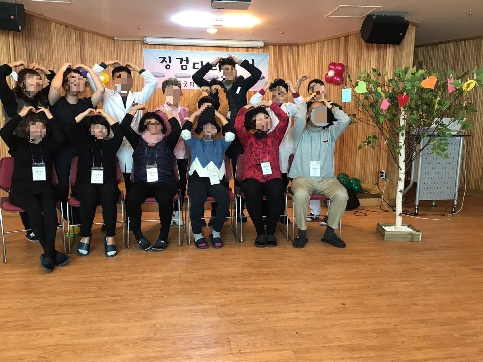 alt="징검다리모임에 참여한 사별가족과 의료진의 단체사진, 하트를 그리며 서로를 위로하는 모습"