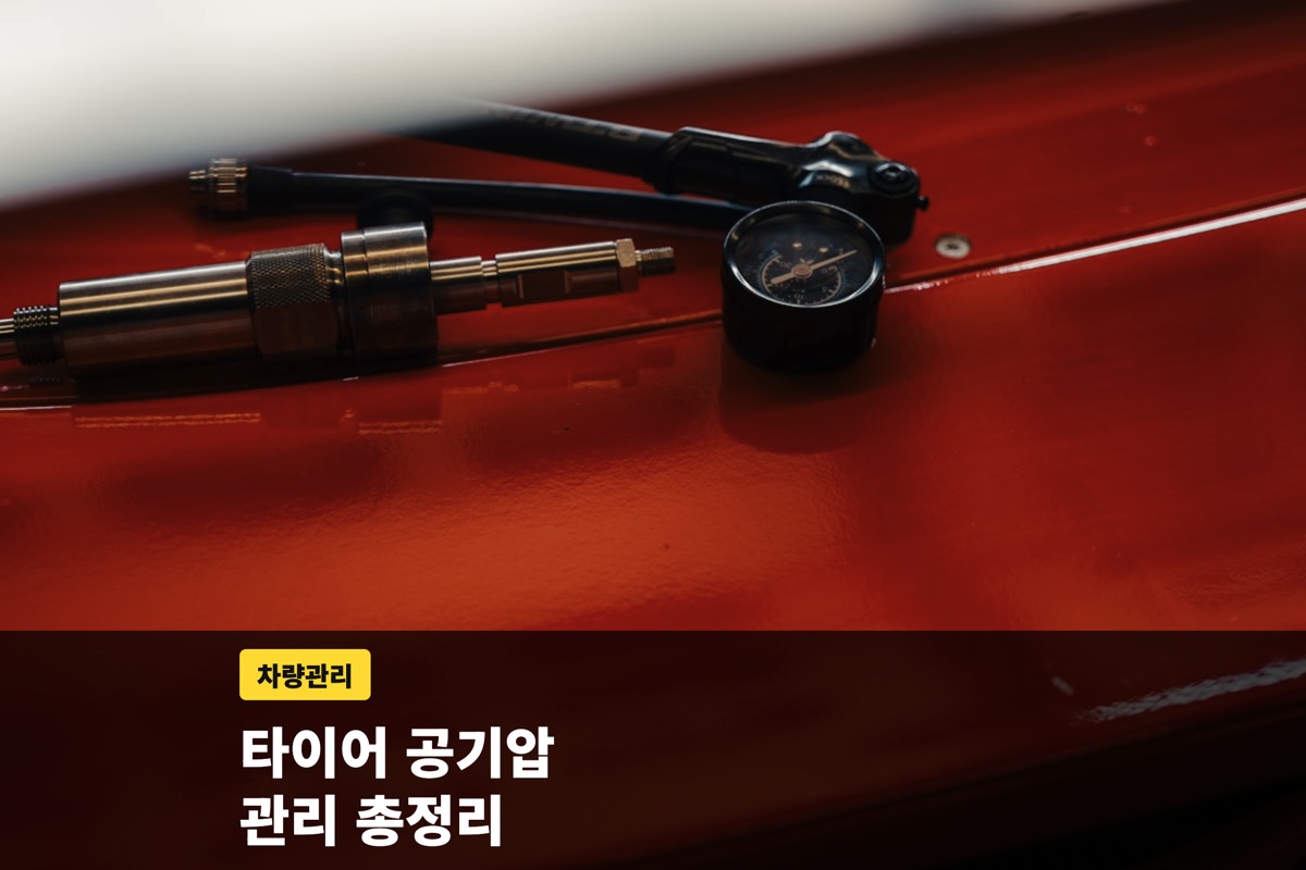 붉은 표면 위에 놓인 공기압 게이지와 호스 연결부