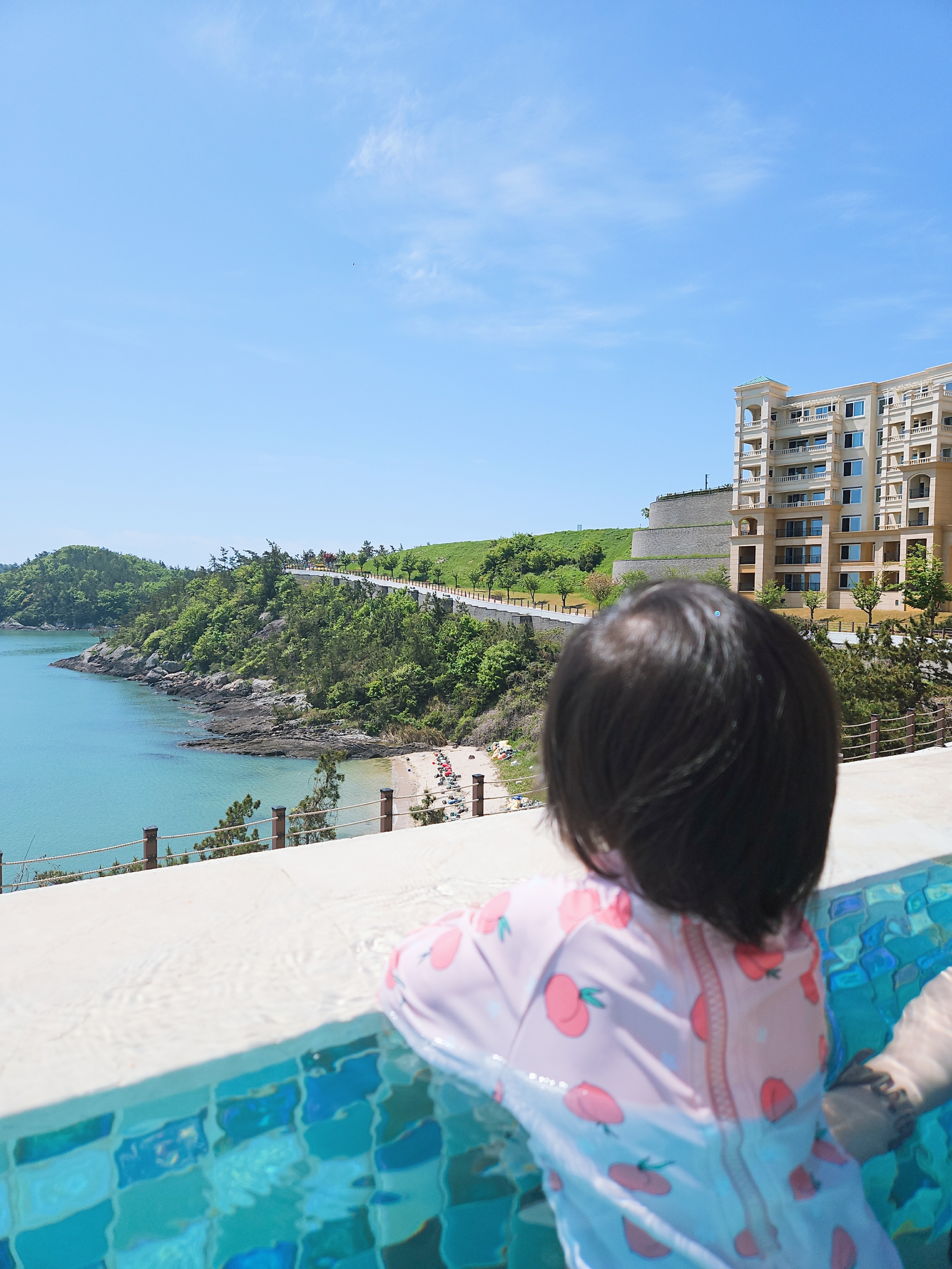 12개월 아이가 인피니티풀안에서 바다를 바라보는 장면