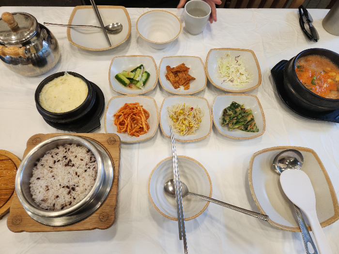 6가지 반찬과 된장찌개&amp;#44; 계란찜&amp;#44; 솥밥이 테이블 위에 있다