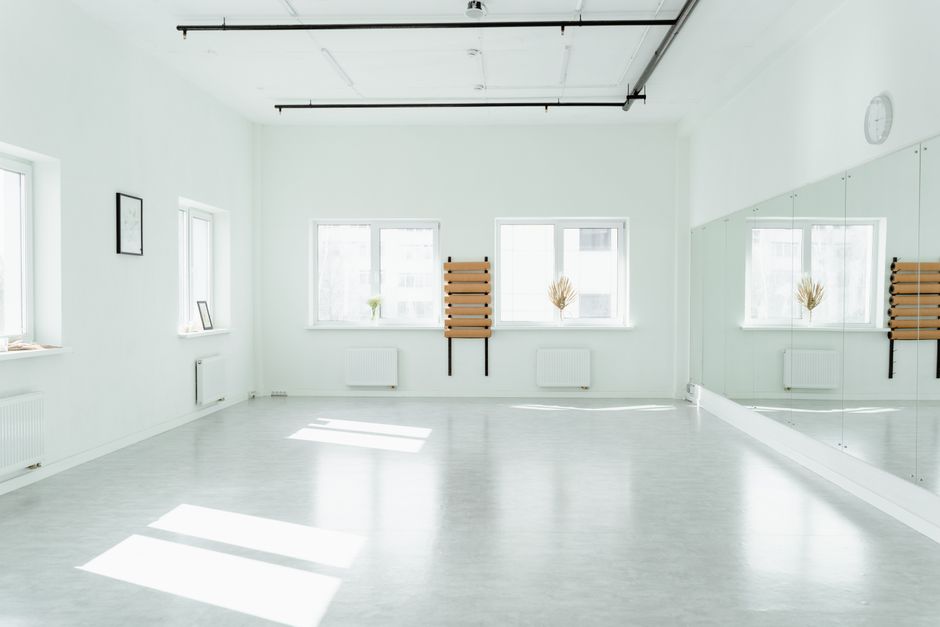 Bright and empty dance studio with mirrors and sunlight streaming in.