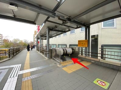 에스컬레이트가 보이고 화살표가 에스컬레이터를 향해 있는 사진