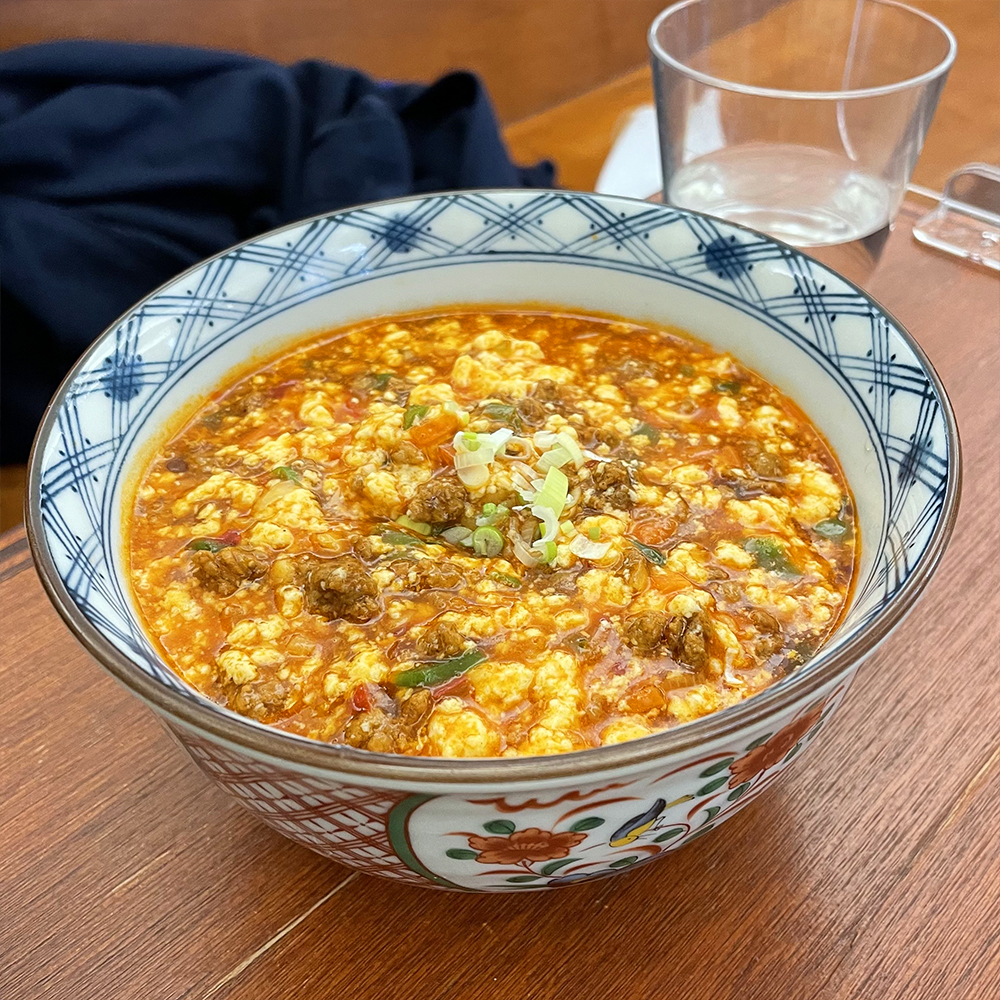 빨간색,-파란색-무늬가-있는-흰색-도자기-그릇-안에-마파순두부-덮밥이-담겨-있습니다.