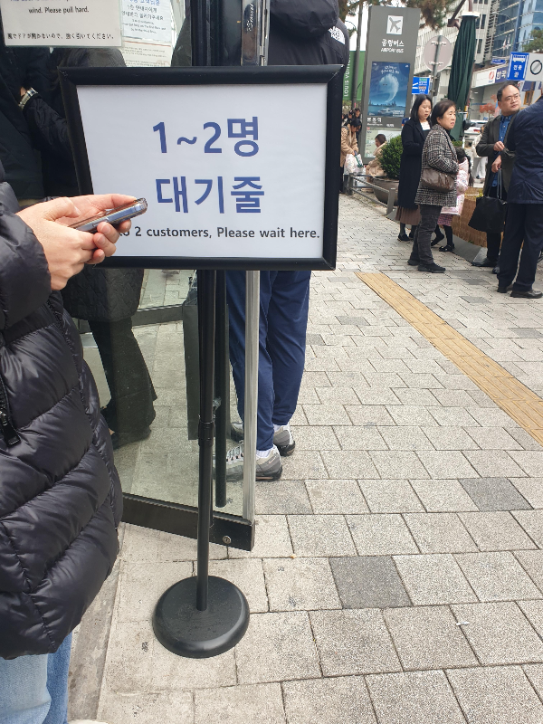 비교적 짧았던 1~2인 대기줄. 대기줄 팻말 뒤에 사람들이 서 있다.