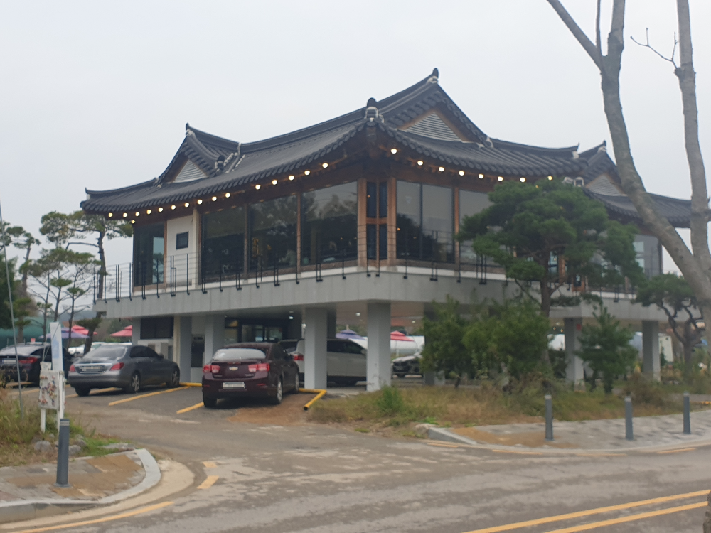 1층 건물 아래에 주차장이 있는 한옥 구조인 카페