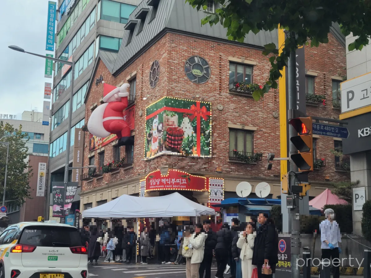 성심당케익부띠끄건물-산타가매달려있는-빨간색간판-하얀색천막아래-줄서있는사람들