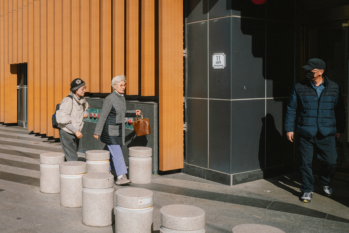 실제로 촬영한 스트릿 사진. 할머니 두 사람이 문으로 향하고 그 문에서 어떤 남자가 나온다. 할머니들과 남자는 서로를 바라보는 찰나를 사진으로 담았다.