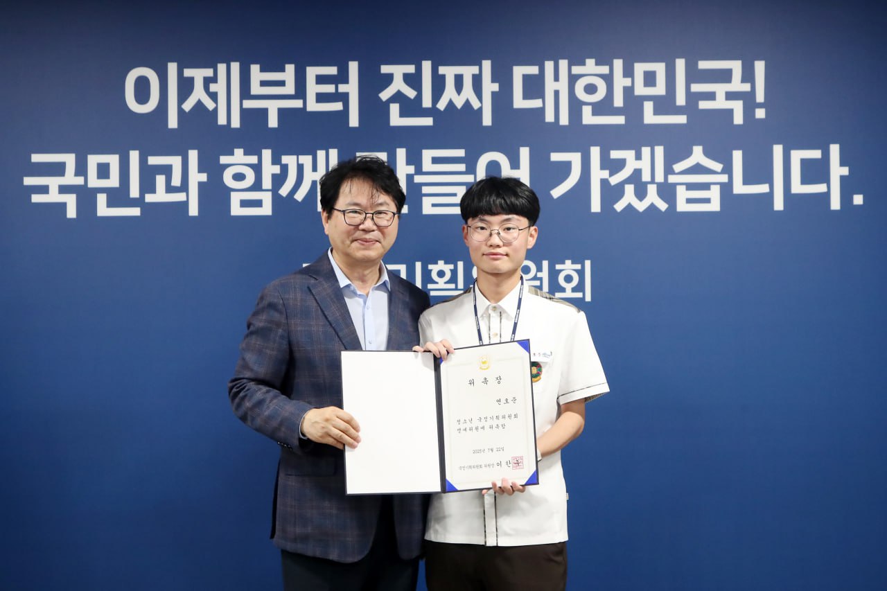 이한주 국정기획위원장님 (좌측) 과 함께 제가 (우측) 위촉장을 들고 서 있는 모습의 사진입니다. 나란히 선 두 사람 뒤로는 국정기획위원회 로고와 함께 '이제부터 진짜 대한민국! 국민과 함께 만들어 가겠습니다.'라는 슬로건이 적혀 있습니다.