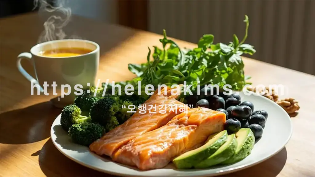 따뜻한 차 한잔과 브로콜리, 연어, 아보카도, 블루베리 등 싱싱한 채소가 접시에 담겨있는 이미지.