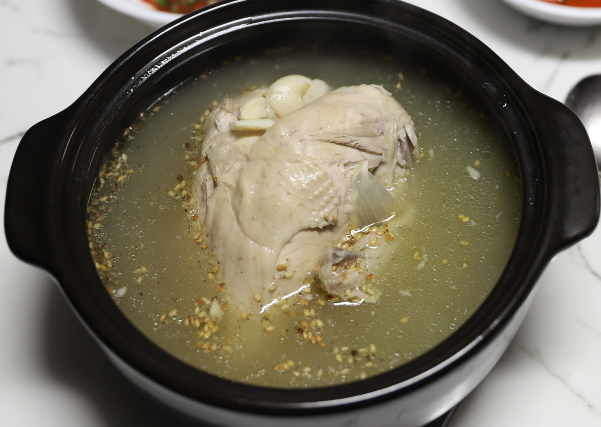 완성된 삼계탕을 뚝배기에 담아낸 모습