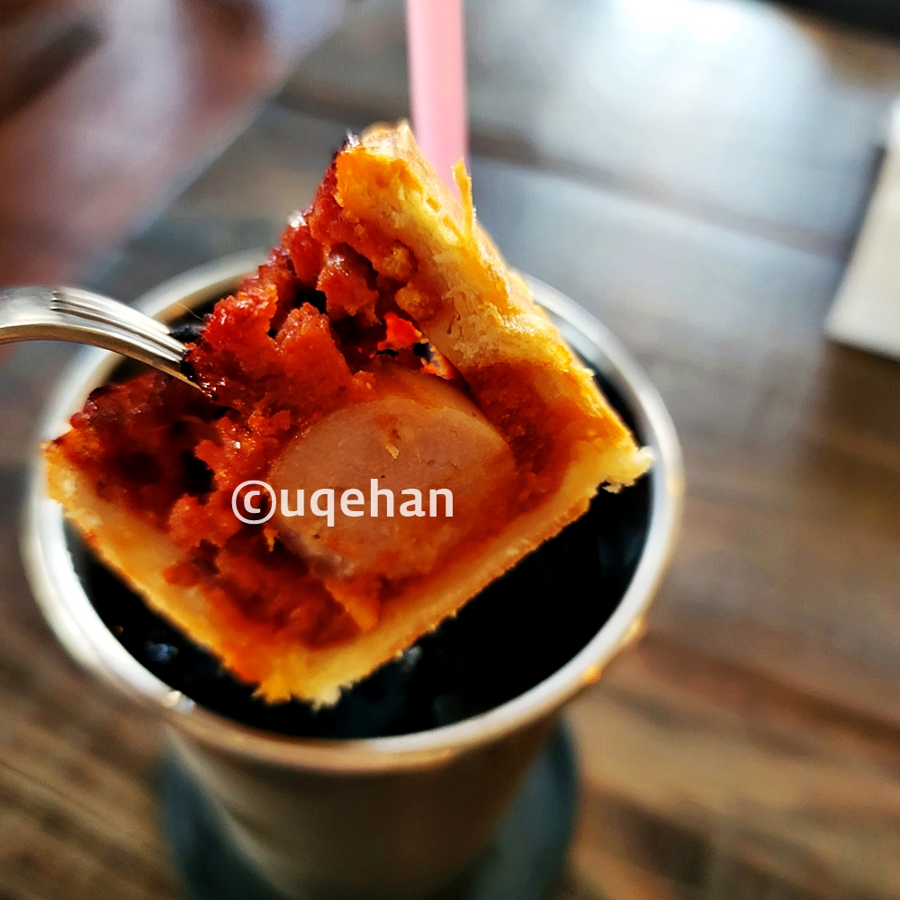 카페 럿지 칠리소시지 빵을 포크로 집어 들고있다.