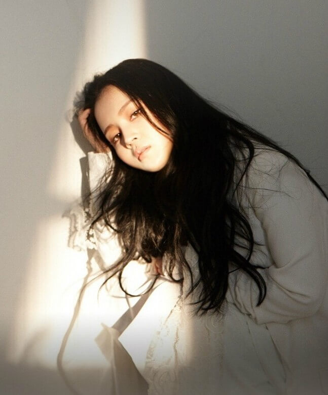 이하이-한숨-이하이가-햇살이-비추는-벽에-기대어-정면을-응시하고-있는-사진