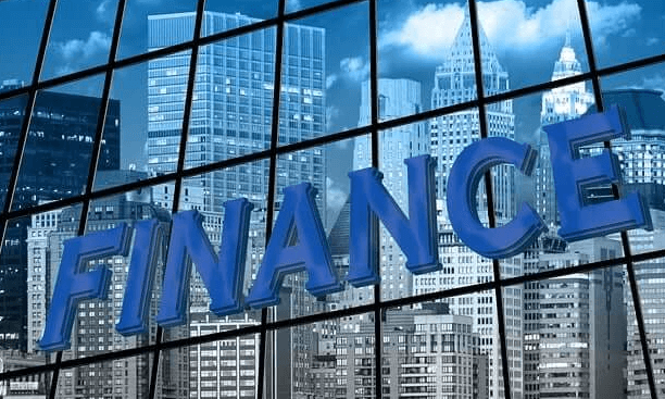 투명유리 건물에 비친 수많은 건물들과 파이넌스라는 영문자가 쓰여있다.