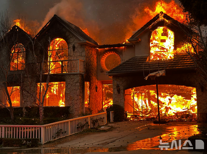 지난 8일(현지시각) 미 캘리포니아주 로스앤젤레스 인근 퍼시픽 팰리세이즈의 한 주택이 산불에 휩싸여 타고 있다. 기후변화로 인한 '날씨 채찍질'이 홍수와 가뭄을 부르면서 이번 산불을 키웠다는 분석이 나온다.