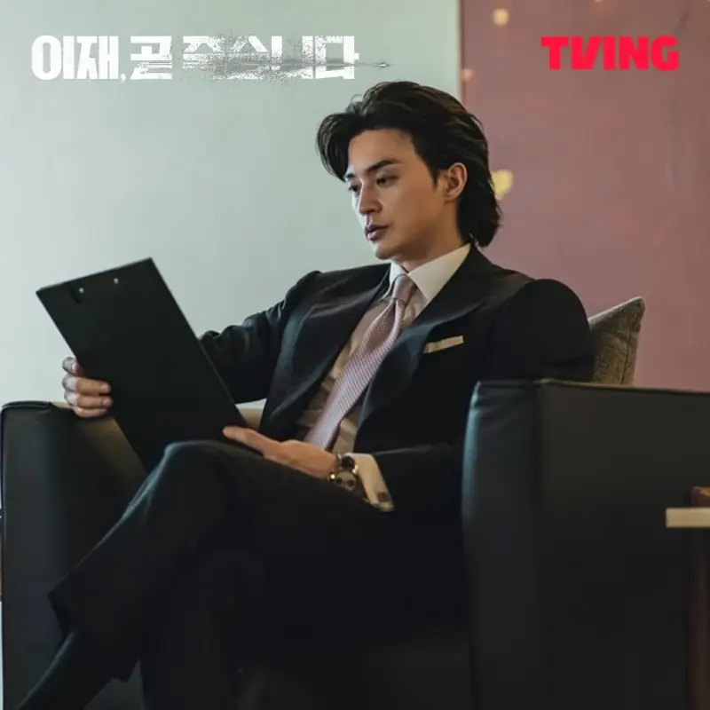 정장 스타일에 소파에 앉아 서류를 보고 있는 드라마 이재, 곧 죽습니다에서 박태우를 연기하는 배우 김지훈