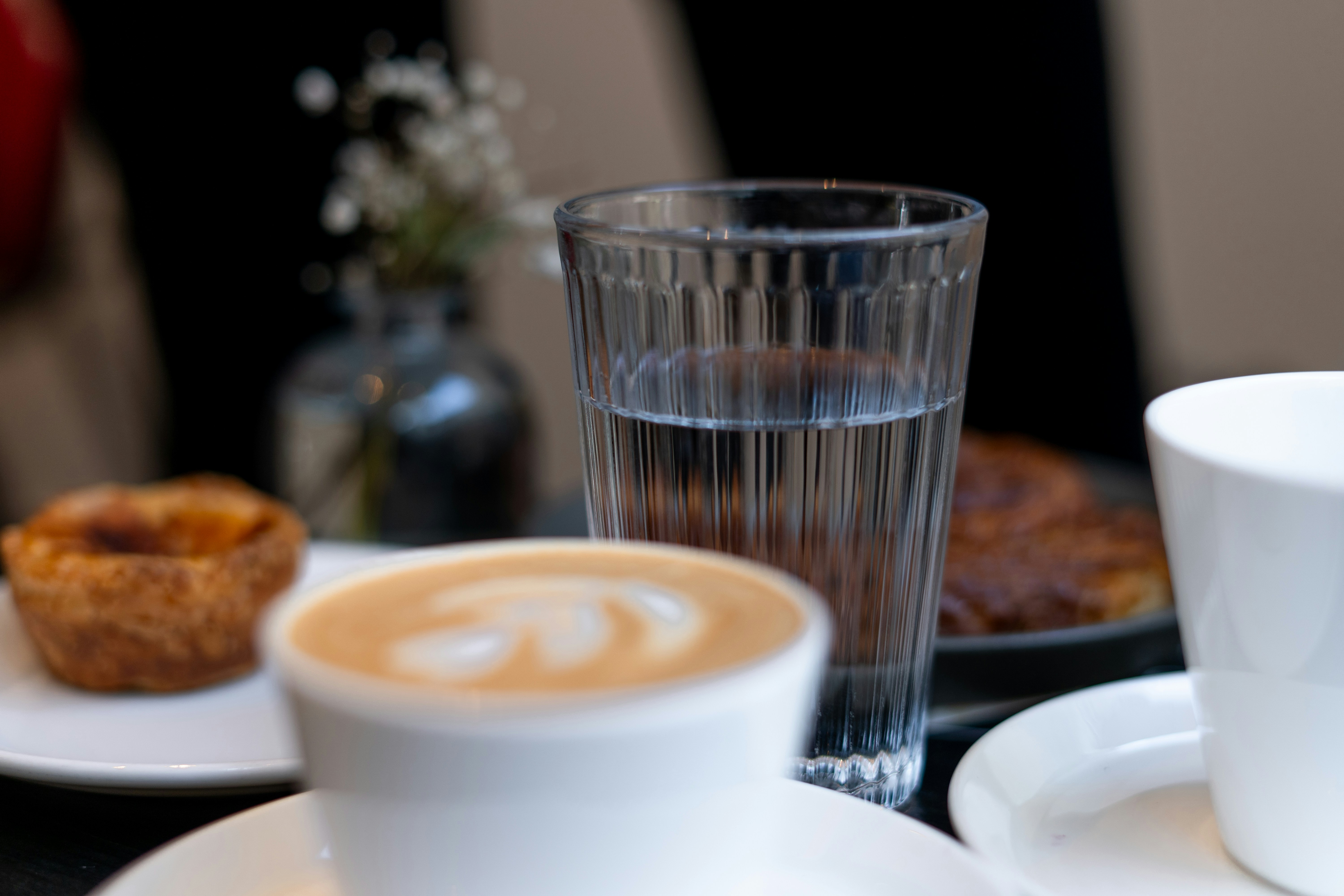 "커피잔과 물컵이 놓인 테이블, 물 대신 커피를 마실 때 생길 수 있는 피로와 갈증 문제를 상징하는 모습"