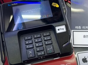 애플페이를 리더기에 가져대 대는 이미지입니다