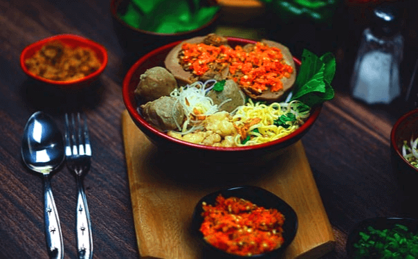 그릇에 미트볼 5개가 있는 국수가 있다. 아이 주먹만한 크기의 미트볼이고, 국수 위에는 야채와 달걀지단이 있다.