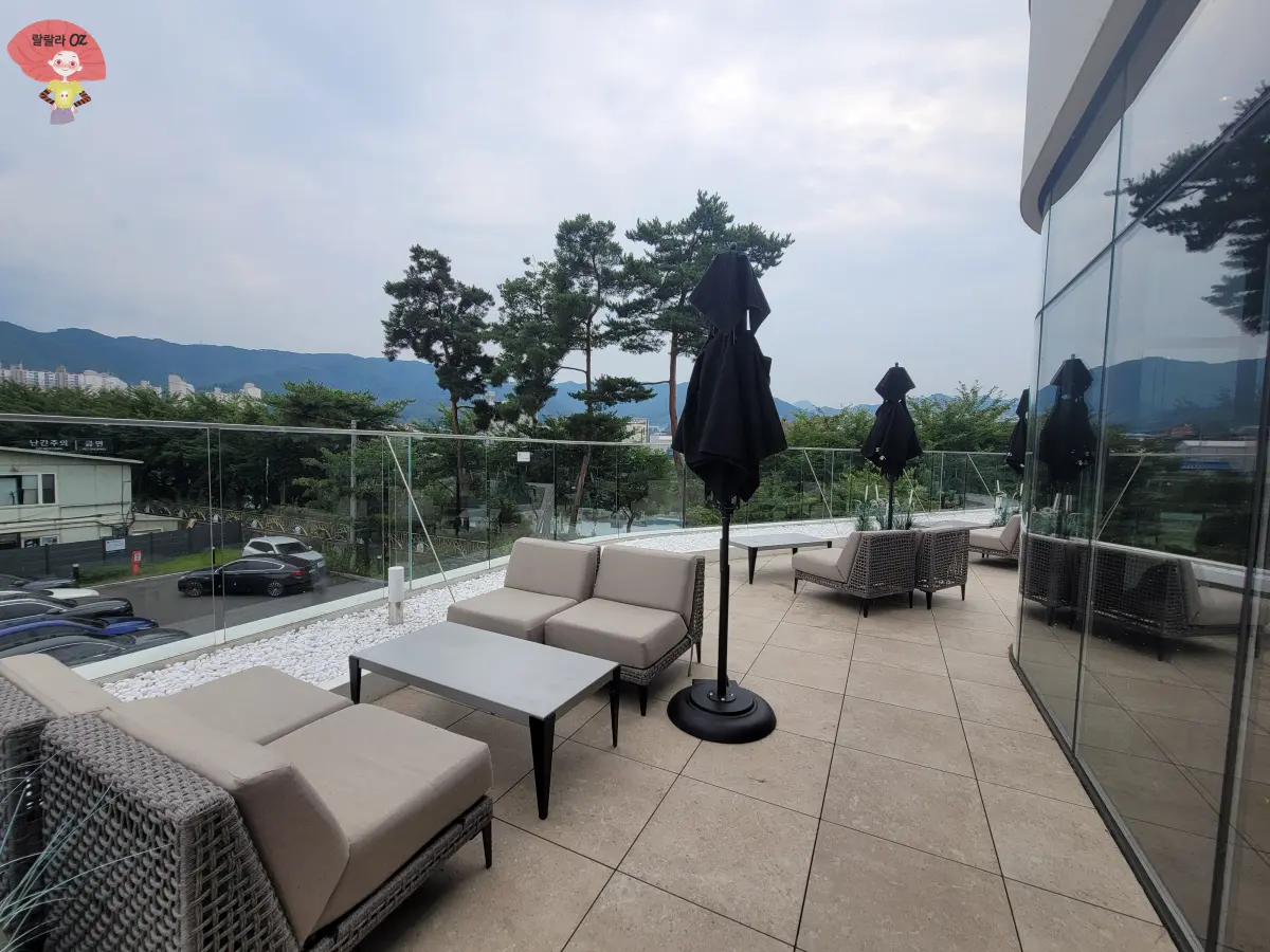 강원도-홍천-스타벅스-2층-테라스-테이블과-의자들-접힌-파라솔이-있고-앞쪽으로-주차장이-보임