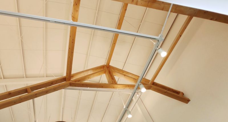 카페 내부에서 보는 높은 천장과 삼각 지붕을 강조한 나무구조물