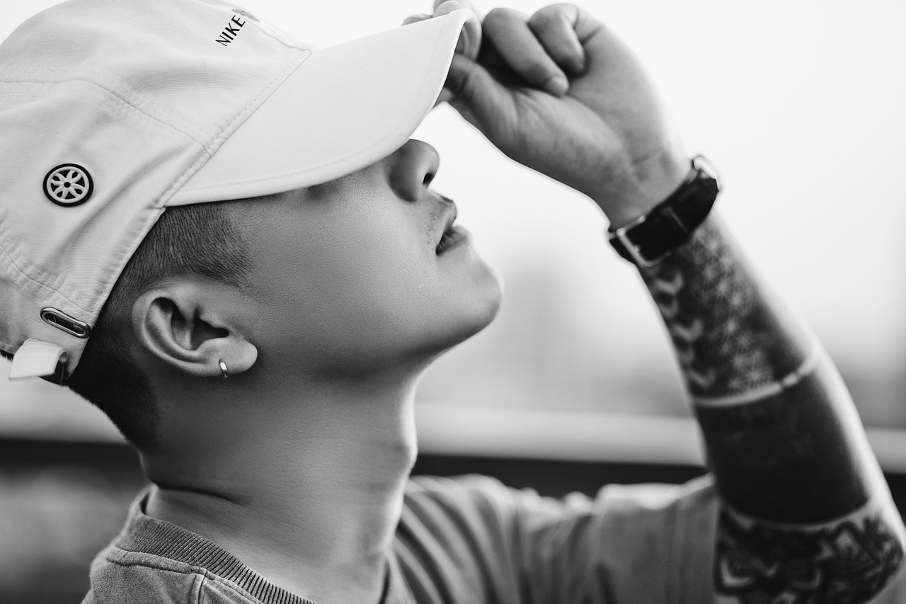 모자를 눌러쓰고 왼손으로 창을 만지며 하늘을 보고 있는 소년