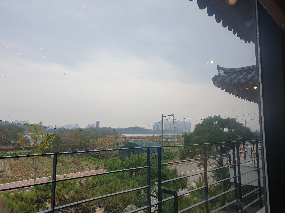 창문 너머 처마가 보이고 그 뒤로 호수가 저 멀리 보인다.