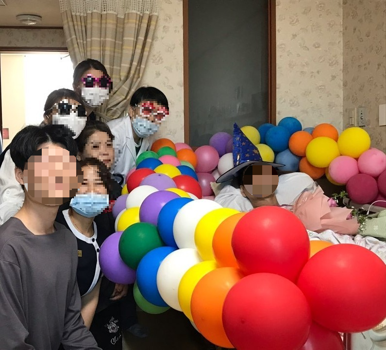 호스피스 병동에서 생신잔치를 기념하는 환우와 가족들, 그리고 의료진이 함께 모여 행복한 순간을 나누는 모습
