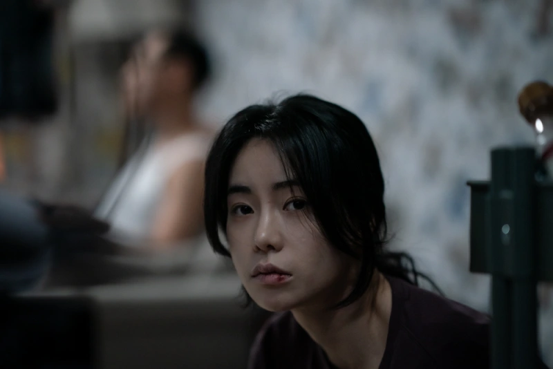 어느 실내를 배경으로 긴 검은 머리를 뒤로 묶고 입술에 상처가 나있는 드라마 마당이 있는 집의 출연 배우 임지연